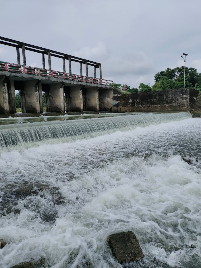 Scenic view of a hydroelectric dam over a river in Sylhet, Bangladesh showcasing flowing water and lush surroundings.